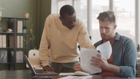 two diverse colleagues analyzing financial documents in office