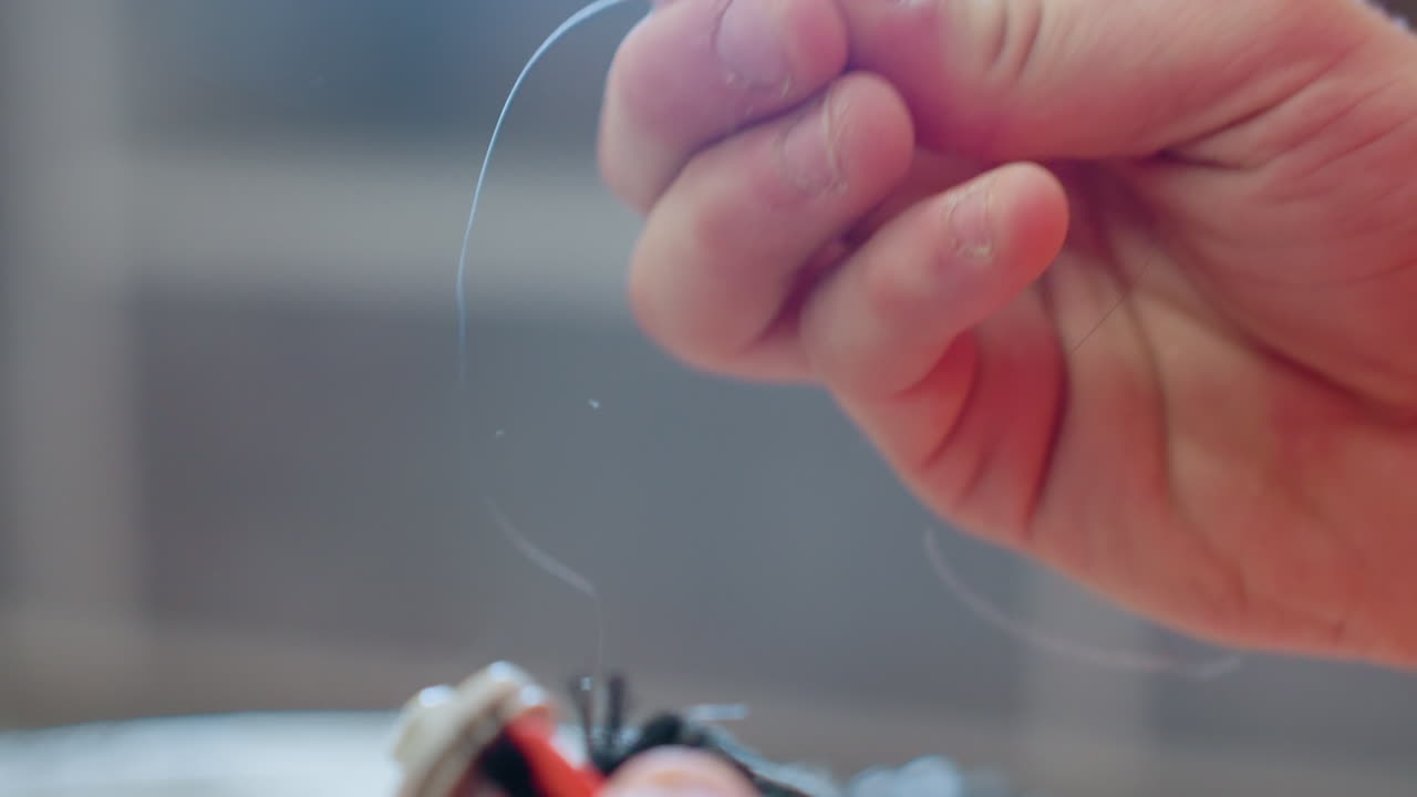 Close up of hands removing tangled hair from vacuum cleaner rotating brush during maintenance to ensure smooth performance, effective cleaning, and proper household appliance repair process