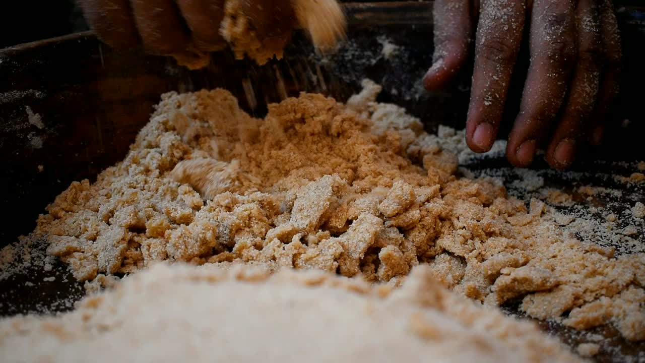 uomo che separa l'impasto dal piatto di legno dalle sue mani per impastare