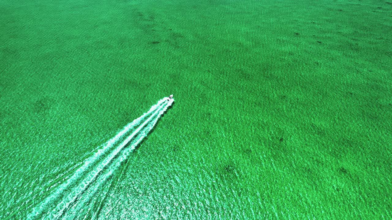 티르코이즈 바하마 평평에서 멀리 이동하는 보트의 위아래 공중 뷰