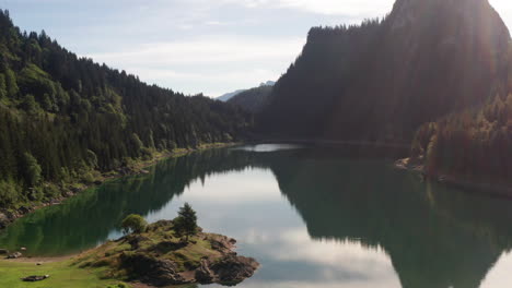 Peaceful-lake-surrounded-by-mountains-in-summer---jib-up