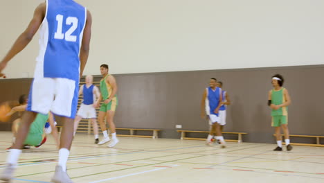 basketball players helping teammates up on court during friendly game