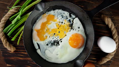 the frying pan with fried eggs slowly rotates on tray.