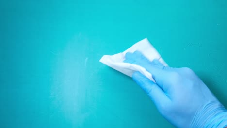 cleaning a turquoise surface with gloves