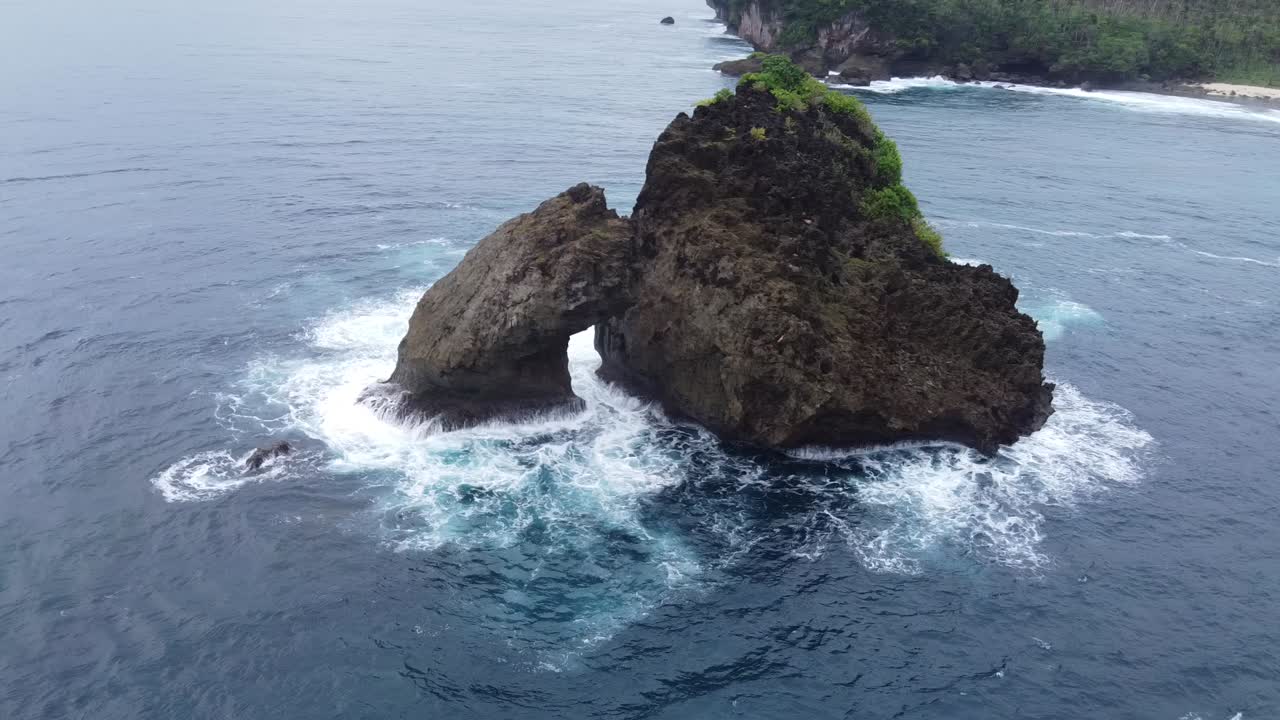 Aerial arc around rock islet in ocean, Siargao, Magpopongko