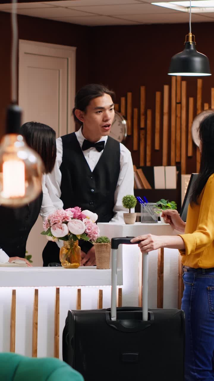 Video verticale: team della reception che accoglie un ospite alla reception di un hotel a cinque stelle