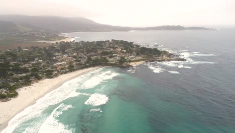 carmel-by-the-sea beach drone video foggy morning surfers on waves - approaching peninsula