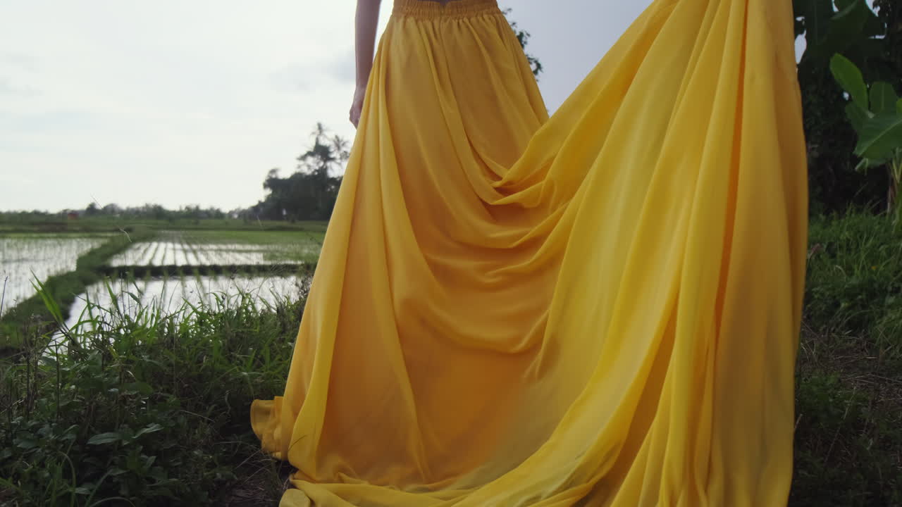 Woman in Yellow Dress Walking Through Rice Paddy Fields
