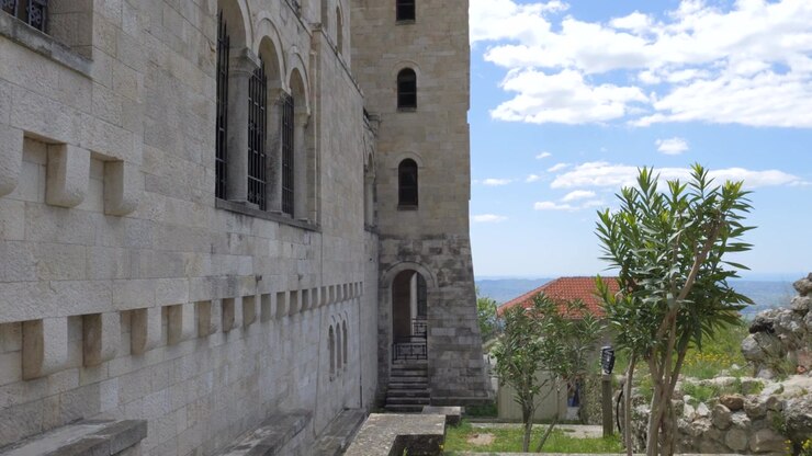 Fortaleza de Krujë, Albânia, fachada de calcário com janelas em arco e escadaria acima do vale