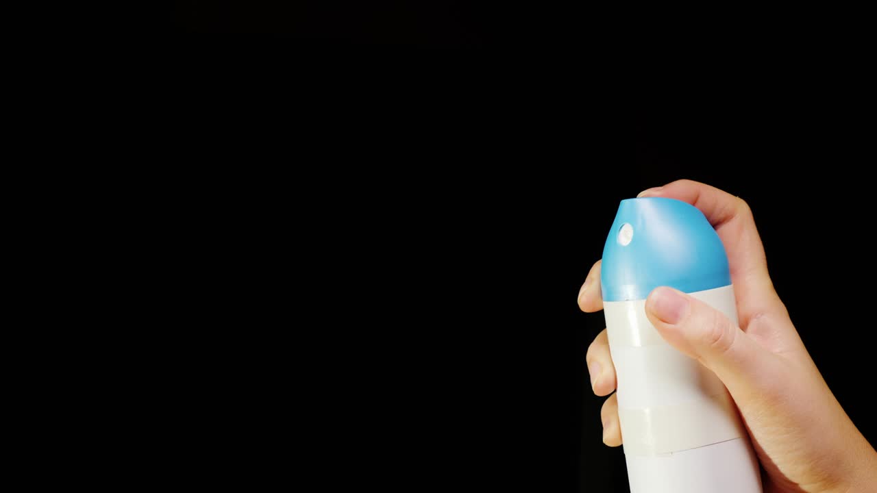 pulverización de una lata de pulverización con un pulverizado sobre un fondo negro