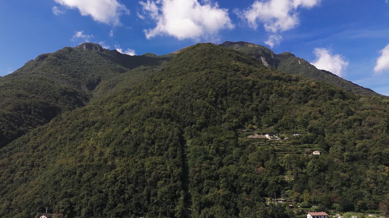 Fly up along green mountain at Lake Como, Italy