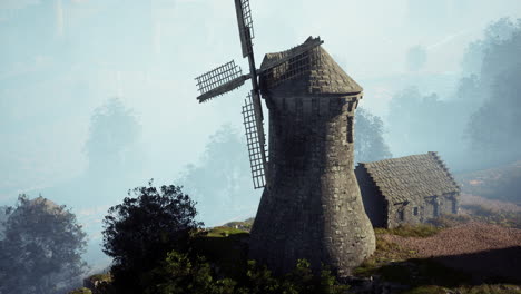 ancient stone windmill on a foggy hilltop