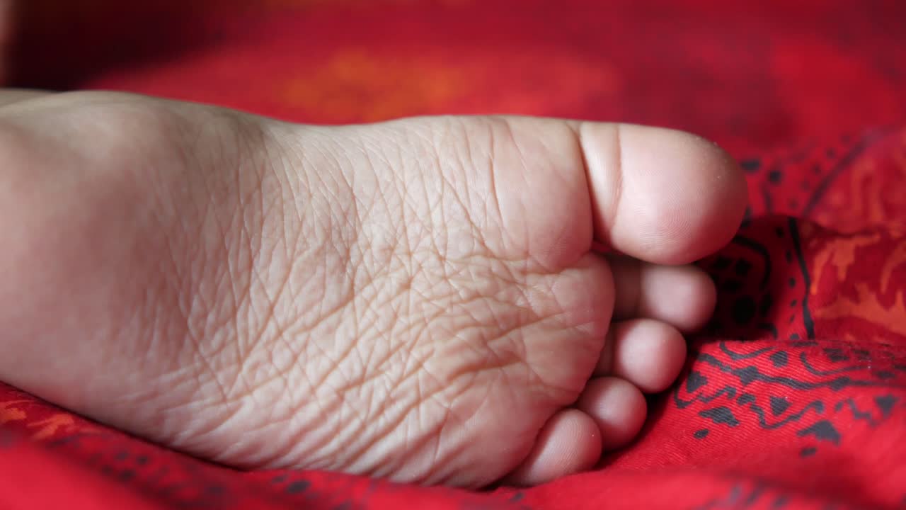 빨간 담요 위에 있는 아이의 발