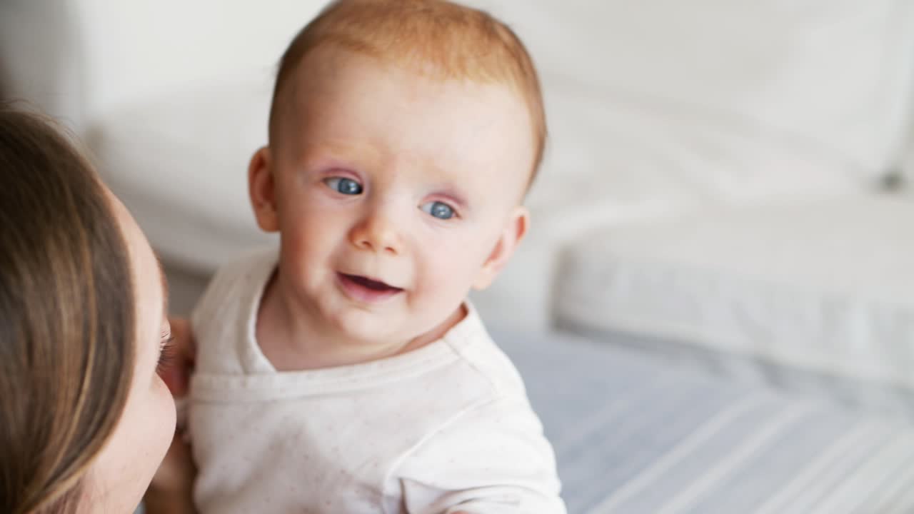 mamá ayudando a la hija bebé a sentarse