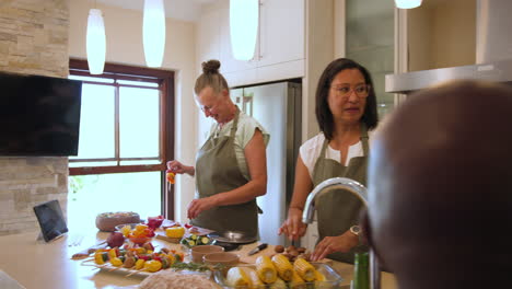 group of diverse friends in kitchen preparing meal and enjoying conversation together, at home
