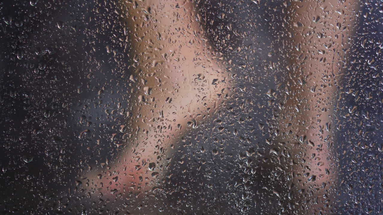 pies de mujer detrás de la cabina de ducha vidrio brumoso con gotas de agua