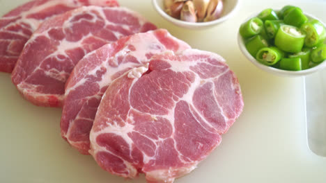 fresh pork neck raw or collar pork on board with ingredients for marinated