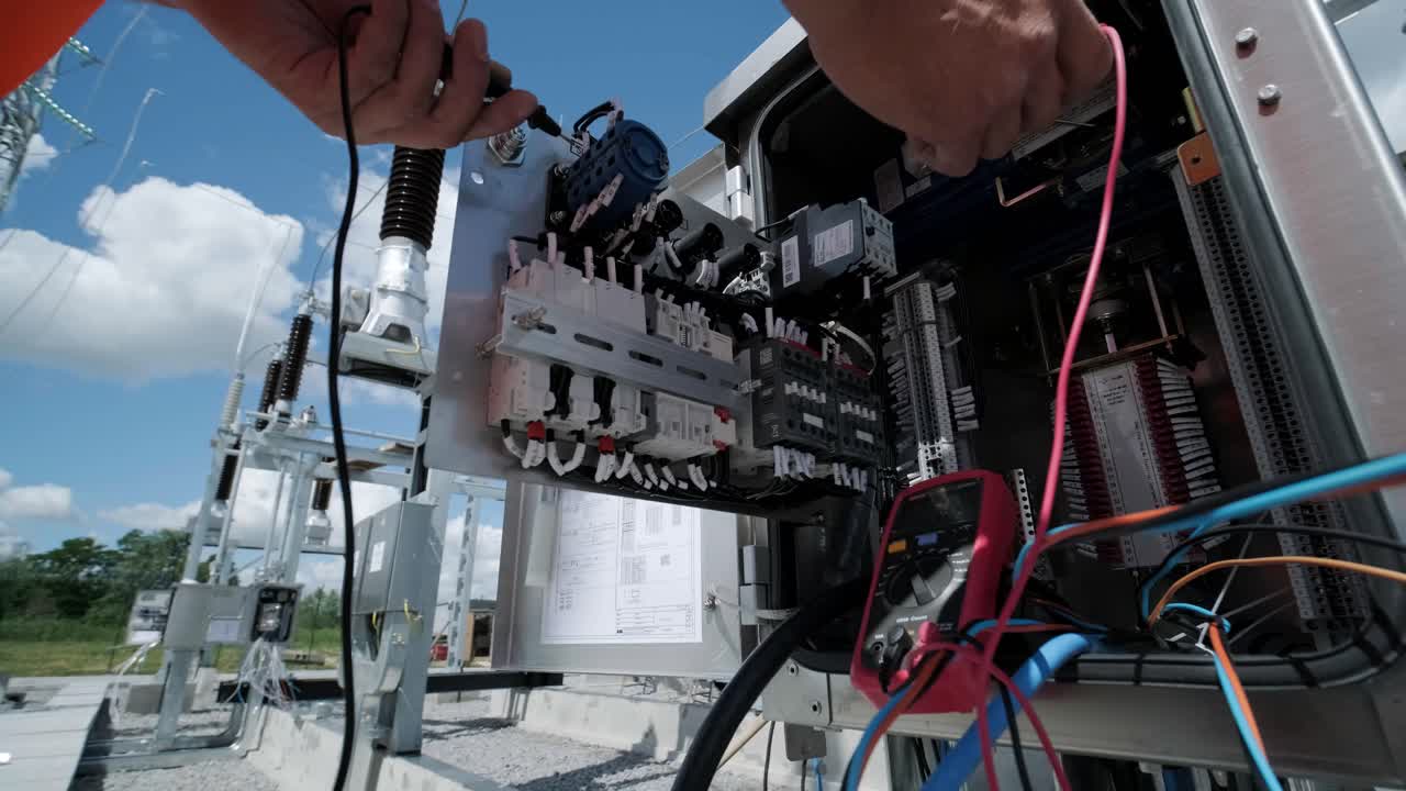 los ingenieros eléctricos inspeccionan los sistemas eléctricos en el gabinete de control de equipos