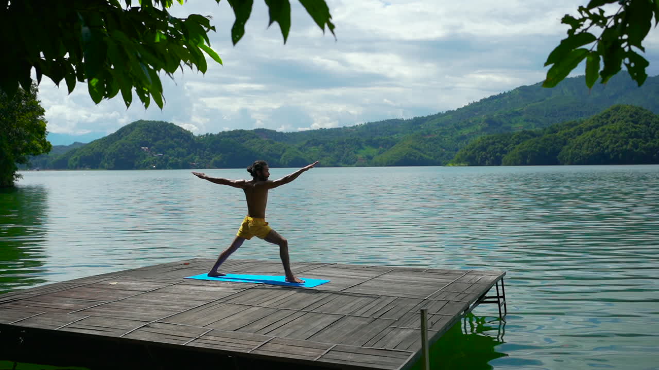 네팔 포카라 의 평화로운 베그나스 호수 를 내려다보는 데크 에서 요가 를 연습 하는 동안 내적 인 평화 를 찾는 사람