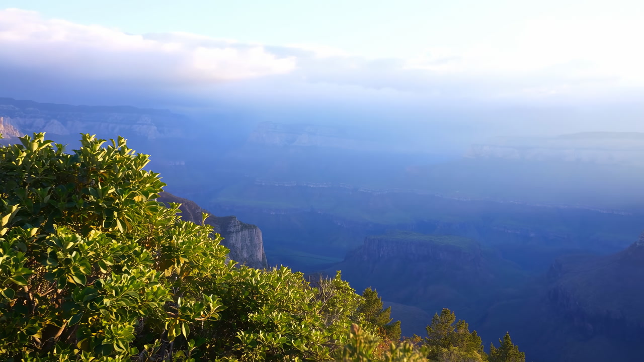 Lush Green Foreground Overlooking Canyon, Layered Mountain Ridges And Deep Blue Valley Under Soft Cloud Layer,