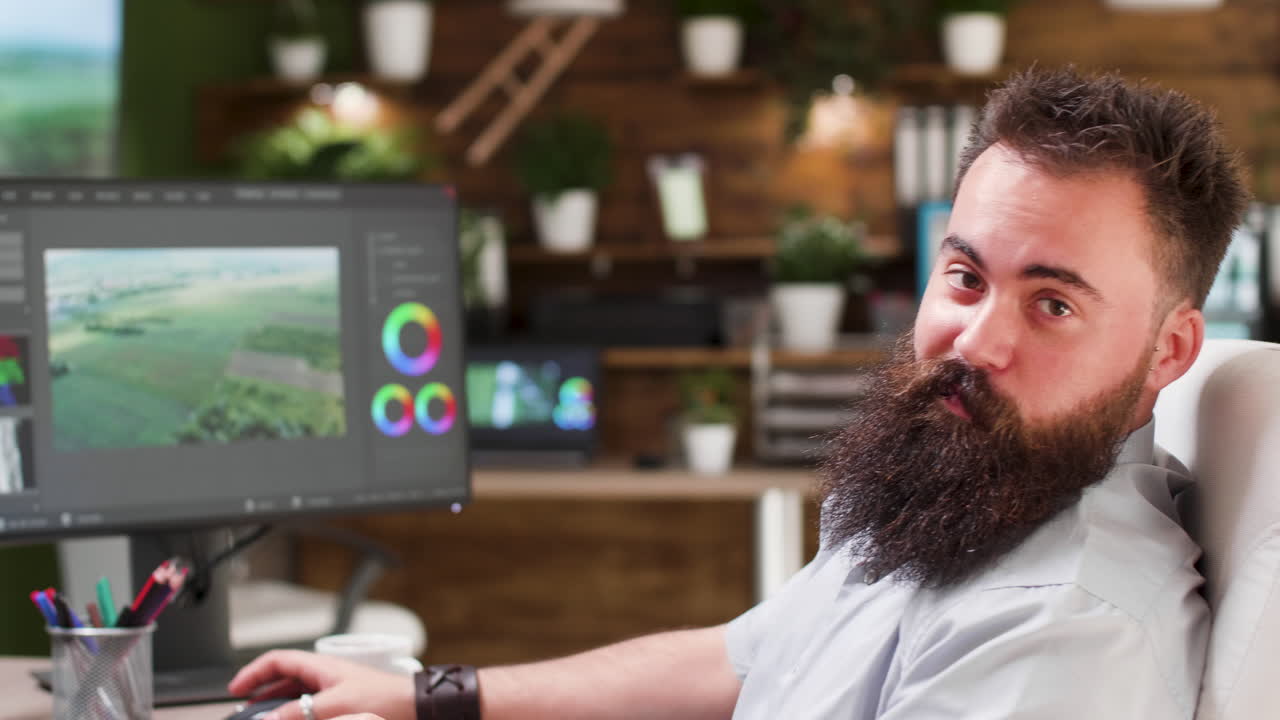 Man in office editing video with software