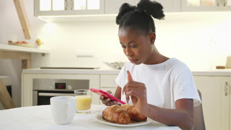woman having breakfast and using mobile phone