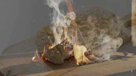 baking bread over open flames, smoke rising in rustic outdoor setting