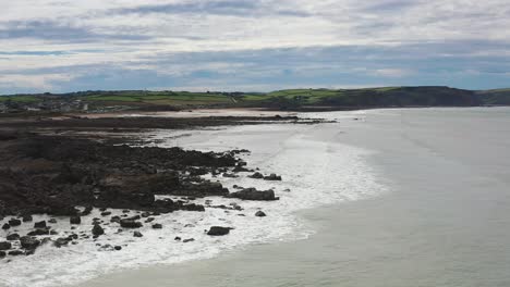 aerial drone flyover beach and rocks in widemouth bay north cornwall