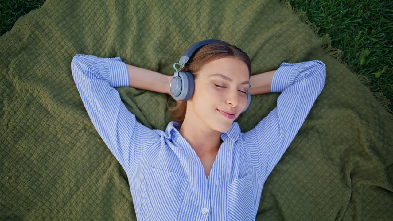 Headphones girl rest picnic blanket closeup. Serene woman listening music