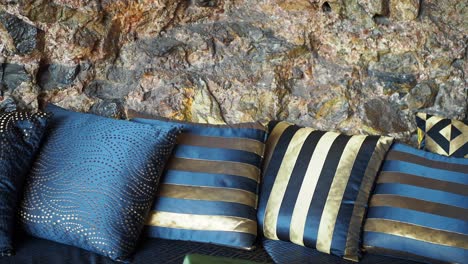 decorative pillows against a stone wall