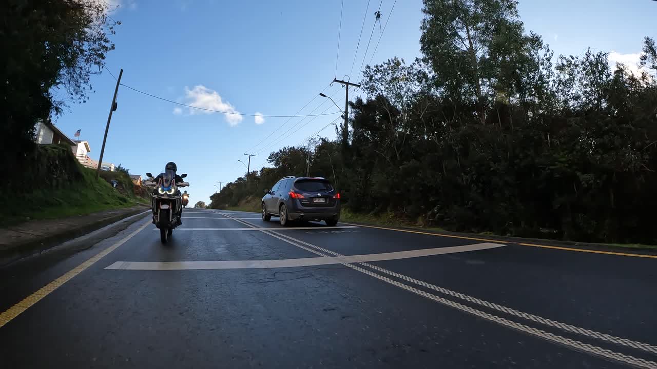 Group of motorcyclists on adventure motorcycles riding on a paved road at sunset. Northern Chilean Patagonia