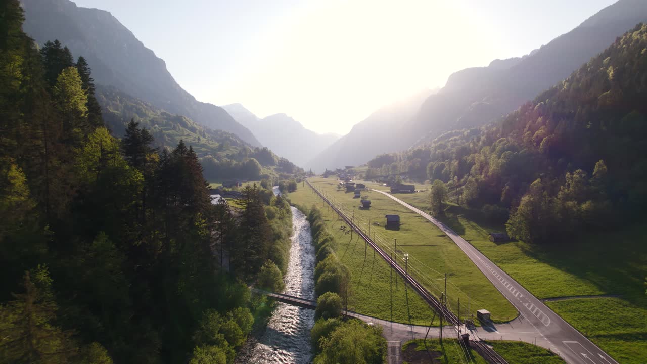 imágenes aéreas de drones empujando y subiendo a lo largo de luetschine negro revelando hermosas vistas de la puesta de sol entre grindelwald y burglauenen en los alpes suizos
