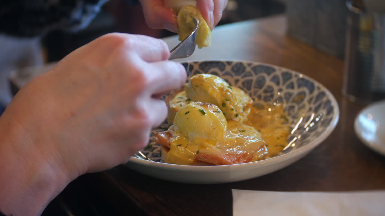 Spremere limone su Uova alla Benedict in un accogliente caffè, che presenta una colazione gourmet per buongustai, turismo e concetti di brunch di lusso.