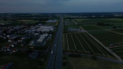 Under-the-darkness-of-night-traffic-on-highway-near-small-European-village