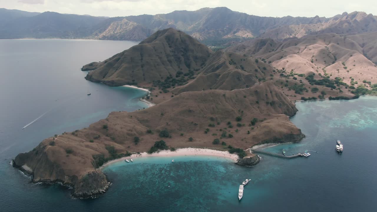Extreme wide drone shot of hidden paradise Island in Indonesia with pink beach and beautiful clear water