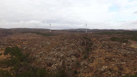 parque eólico de lindesnes antena ascendente con dos molinos de viento en el centro del marco - paisaje natural plano y entorno forestal con nubes brillantes en el fondo