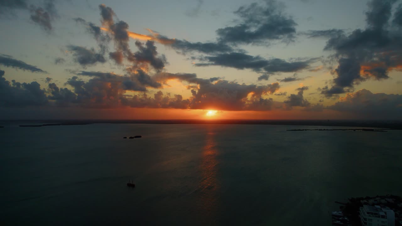 puesta de sol naranja cinematográfica en el horizonte sobre las tranquilas aguas del mar caribe