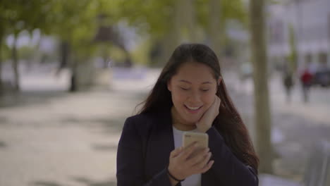 Schockiertes-Glückliches-Mädchen,-Das-Im-Freien-Sein-Smartphone-Benutzt