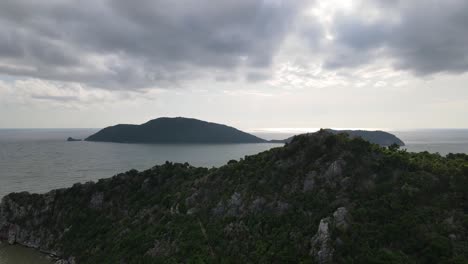 An-aerial-footage-towards-two-islands-in-the-middle-of-the-sea-as-the-drone-flies-over-a-limestone-mountain