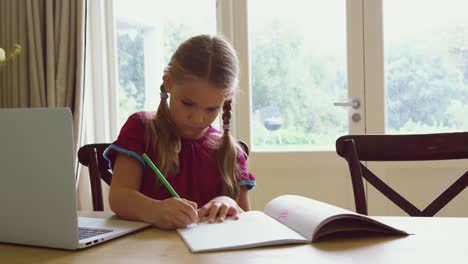 Girl-doing-homework-at-dining-table-in-a-comfortable-home-4k