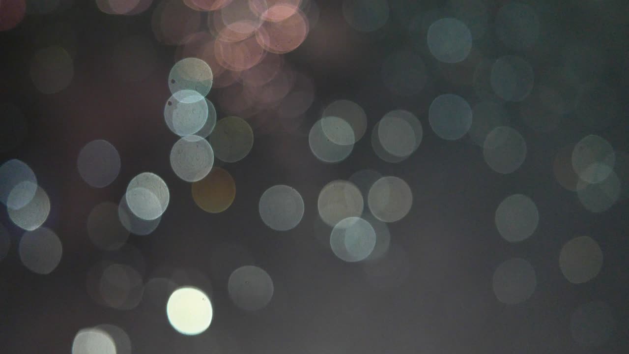 luces nocturnas de la ciudad desde una ventana lluviosa