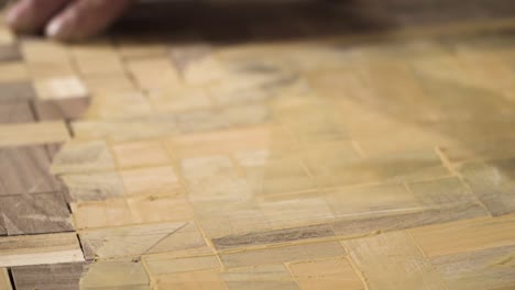 Close-shot-of-a-spatula-spreading-wooden-paste-on-a-wood