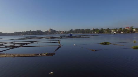 bamboo hut structure for local aquaculture provide domestic food needs of small rural farming community in sampaloc lake, laguna. drone, aerial shot