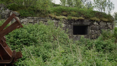 gimbal shot moving past rusty machinery and bunker window at coastal battery