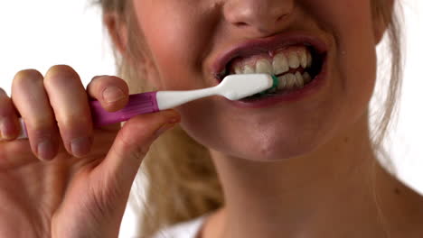 mujer cepillándose los dientes sobre un fondo blanco