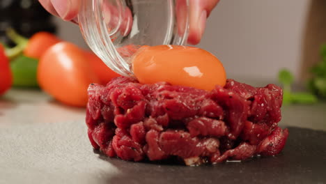 preparing beef tartare with egg yolk
