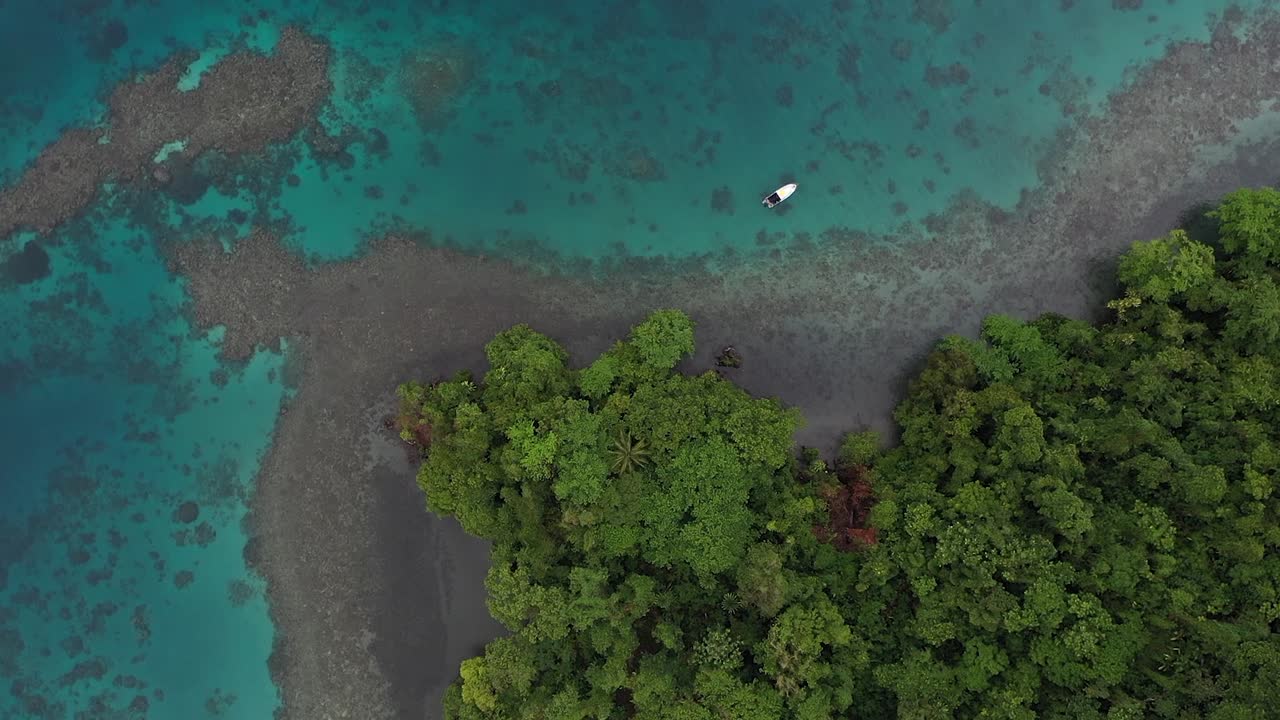 회색 화산암은 작은 섬에서 아름다운 청록색과 푸른 물이 있는 산호초로 나갑니다.