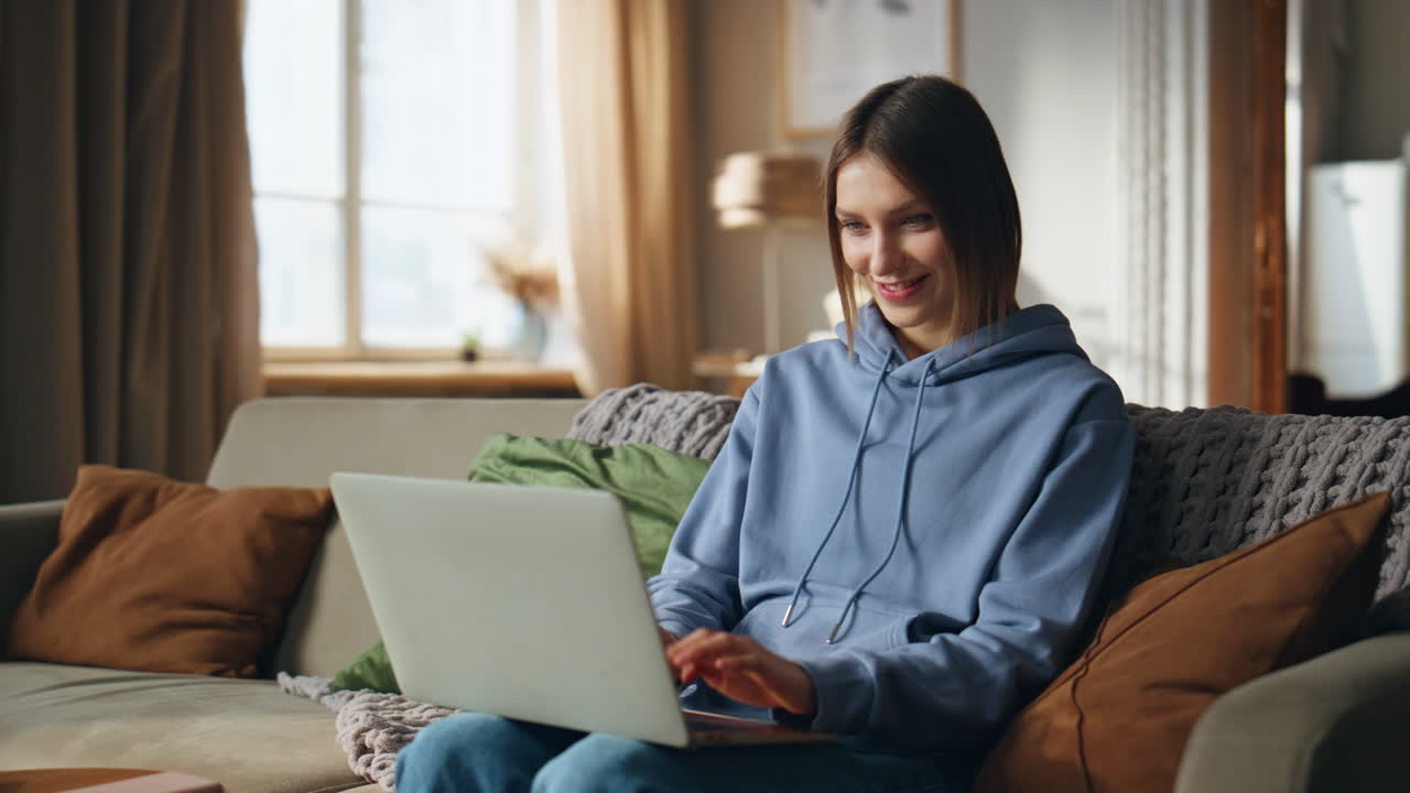 mujer usando una computadora portátil en el sofá