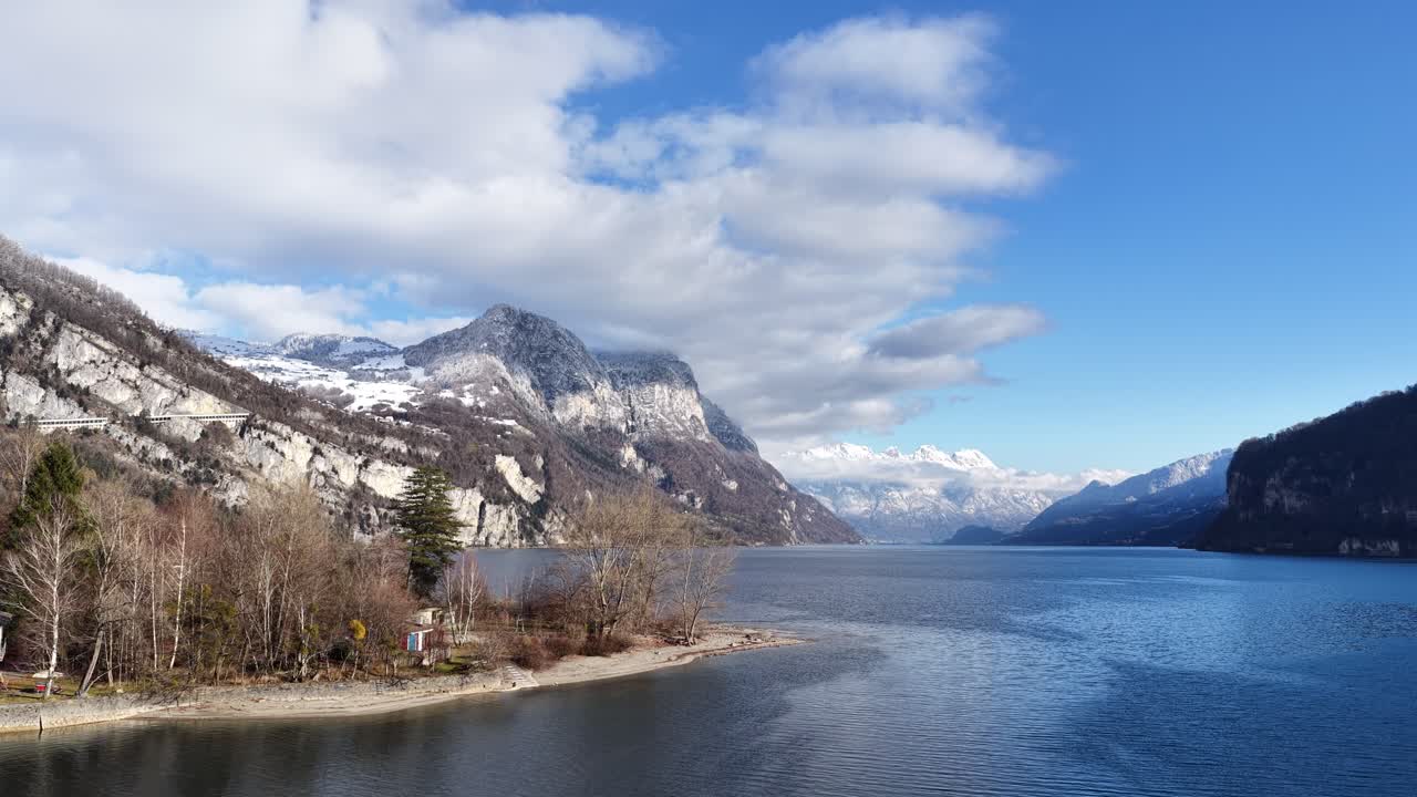 Walensee, Switzerland drone view across clear blue lake with alpine mountains and winter peaks, peaceful European landscape and natural environment