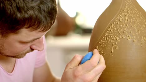 artisan creating a decorated pottery vase